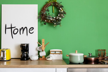 Easter wreath hanging on green wall in interior of kitchen