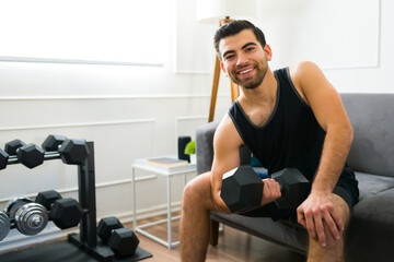 Fototapeta na wymiar Strong fit man looking happy at his home gym