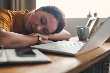I missed the offramp to my bed. Shot of a young woman sleeping at her desk while working from home.