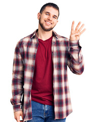 Young handsome man wearing casual shirt showing and pointing up with fingers number four while smiling confident and happy.