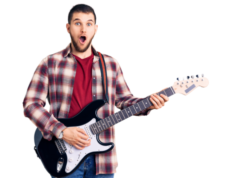 Young handsome man playing electric guitar scared and amazed with open mouth for surprise, disbelief face