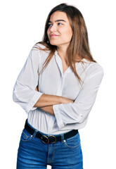 Young caucasian girl wearing casual white shirt looking to the side with arms crossed convinced and confident