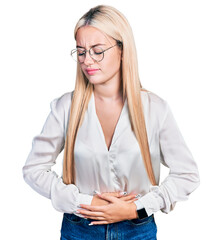 Beautiful blonde woman wearing elegant shirt and glasses with hand on stomach because indigestion,...