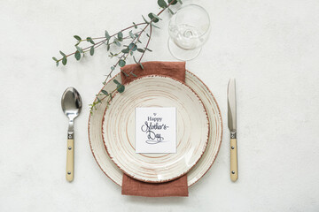 Table setting with eucalyptus branch for Mother's Day celebration on light background