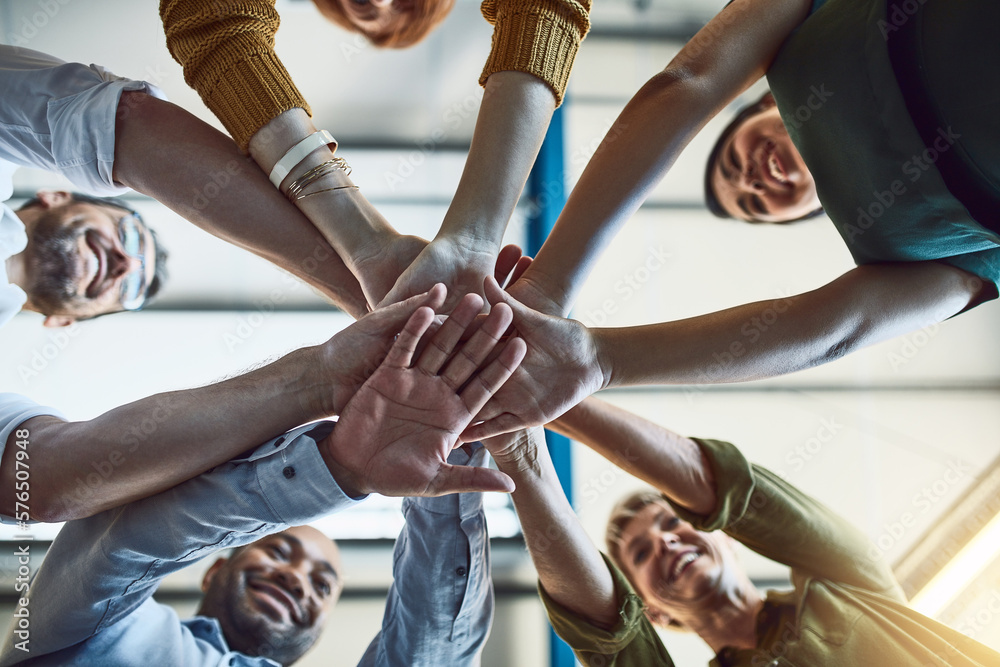 Poster the supportive team is a strong team. low angle shot of a group of colleagues joining their hands in
