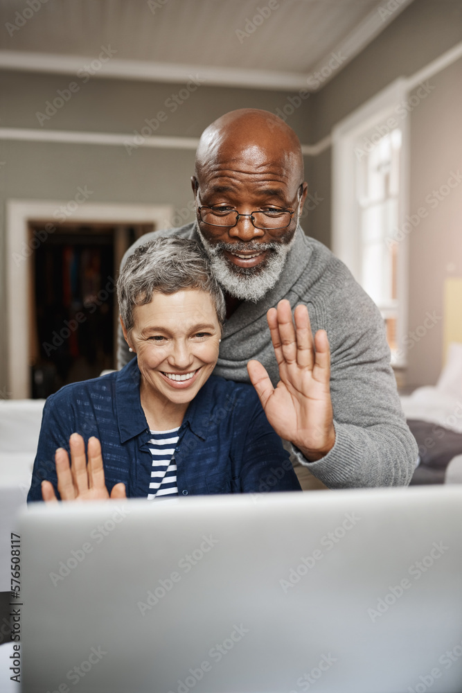 Poster connect to loved ones wherever you are. shot of a senior couple waving while using a laptop at home.