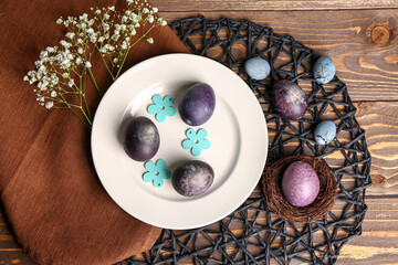 Composition with beautiful Easter eggs, gypsophila flowers and decor on wooden background