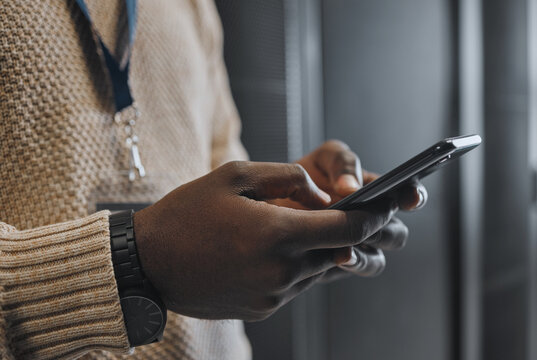 Phone, search or IT black man hands in data center for research, communication or typing in server room. Mobile, focus or male on smartphone for networking, social media or reading website content
