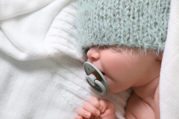 Fototapeta premium Cute newborn baby with pacifier sleeping on white blanket, top view