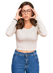 Young brunette woman wearing casual clothes and glasses with hand on head for pain in head because stress. suffering migraine.