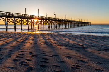 Sunrise Creating Shadows Through Pier