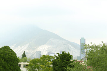 Obraz premium Picturesque view of city with buildings and trees near mountains