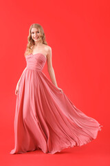 Teenage girl in pink prom dress on red background © Pixel-Shot