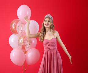 Teenage girl in tiara and prom dress with balloons on red background © Pixel-Shot