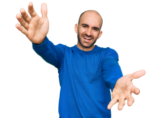 Young hispanic man wearing casual clothes looking at the camera smiling with open arms for hug. cheerful expression embracing happiness.