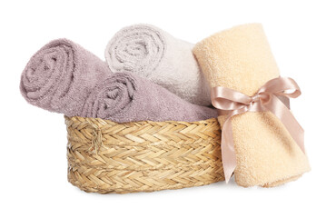 Wicker basket and rolled bath towels on white background
