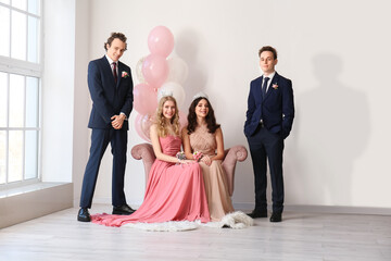 Beautiful couples dressed for prom in room - obrazy, fototapety, plakaty
