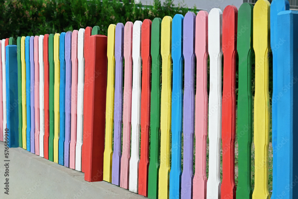 Sticker Colorful wooden fence on sunny day outdoors