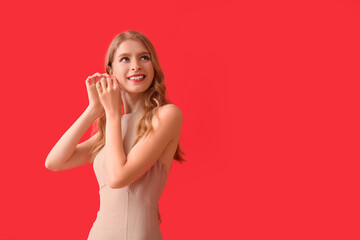 Teenage girl in prom dress on red background © Pixel-Shot