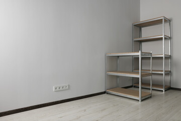 Office room with white walls and metal storage shelves. Space for text
