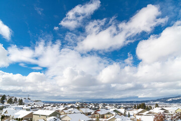 View from a hillside subdivision overlooking the cities of Liberty Lake, Spokane Valley and Spokane, Washington, USA, under blue skies and fresh winter snow.