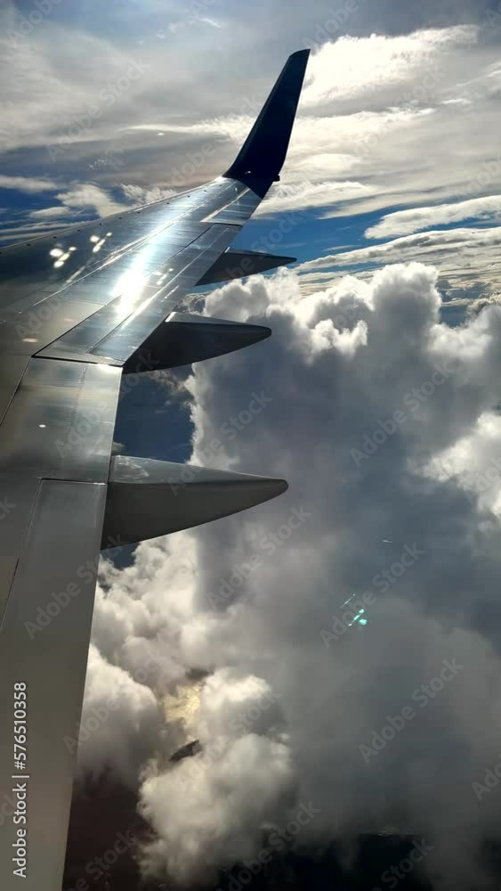 Wall mural exceptionally beautiful jet airplane window view of clouds reflected in aircraft wing. generic trave