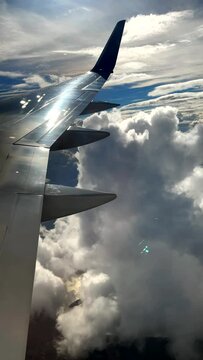 Exceptionally beautiful jet airplane window view of clouds reflected in aircraft wing. Generic travel video.
