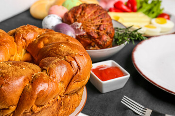 Tasty Easter wreath bread and dishes for dinner on table, closeup