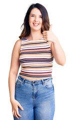 Fototapeta premium Beautiful young brunette woman wearing casual clothes smiling happy and positive, thumb up doing excellent and approval sign