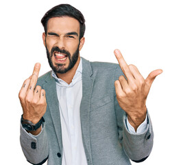 Young hispanic man wearing business clothes showing middle finger doing fuck you bad expression,...