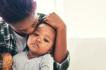 Hes growing up so fast. Shot of a mother cradling her little baby boy.