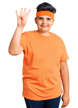 Little boy kid wearing sportswear showing and pointing up with fingers number four while smiling confident and happy.