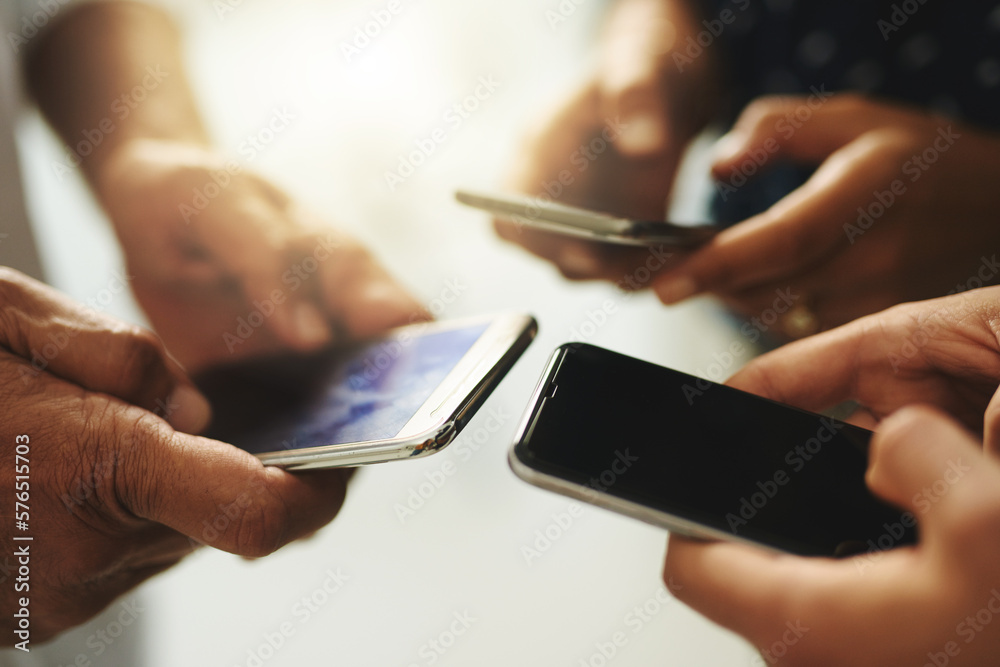 Poster Get connected and stay in the know. Closeup shot of a group of unrecognizable businesspeople using their cellphones in synchronicity.