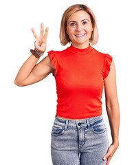 Young blonde woman wearing casual clothes showing and pointing up with fingers number three while smiling confident and happy.