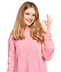 Beautiful young caucasian girl wearing casual winter sweater smiling positive doing ok sign with hand and fingers. successful expression.