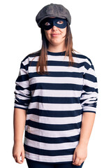 Fototapeta premium Young beautiful brunette woman wearing burglar mask smiling looking to the side and staring away thinking.