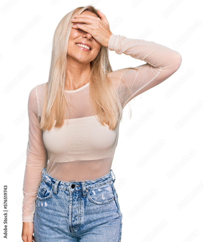 Poster Young blonde woman wearing casual clothes smiling and laughing with hand on face covering eyes for surprise. blind concept.