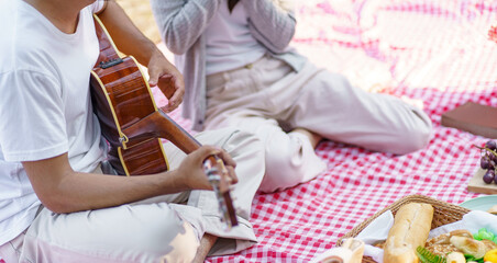Fototapeta premium In love couple enjoying picnic time in park outdoors Picnic. happy couple relaxing together&nbsp;with picnic Basket