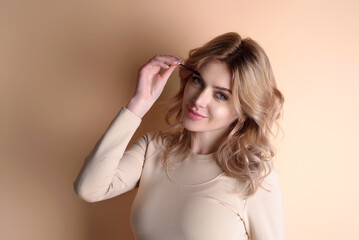 Beautiful woman applies brow gel with brows brush to her eyebrow. Studio portrait of young woman...