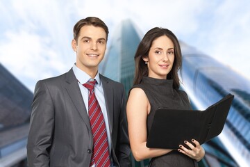 Business partners standing and posing with skyscraper background