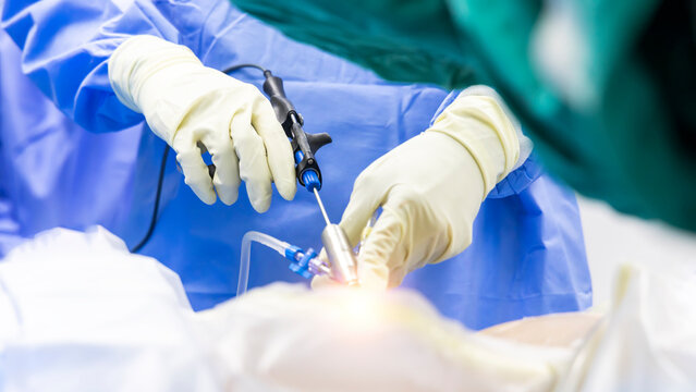 Selective focus with blur background.Surgeon picking up surgical instruments for doctor inside operating room in hospital.Doctor in blue uniform does minimal invasive endoscopic keyhole spine surgery.