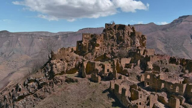 View on ruins of an ancient village on a mountain top. Drone flying over rocks in Caucasus mountains.