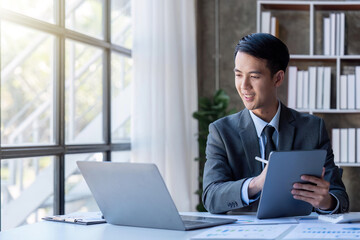 Businessman financing accounting Concept, businessman using tablet and doing finances, calculate about cost to real estate investment and in other, tax system