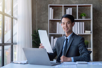 Fototapeta premium Busy businessman accountant Asian male making look document in office working, , report, tax, accounting, statistics, and analytic research concept