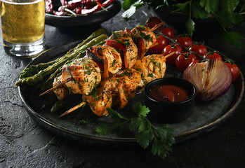 grilled meat on skewers with beer, cherry tomatoes and asparagus