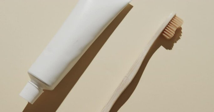 Close up of toothbrush and toothpaste on beige background