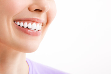 Perfect white teeth smile of a young woman. The result of the teeth whitening procedure. The image symbolizes oral care dentistry, Closeup on a white background.