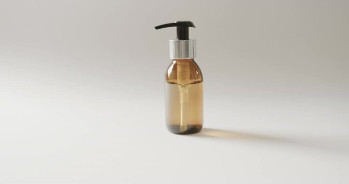 Close up of glass bottle with pump with copy space on white background