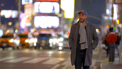 Afro-American man walking in Manhattan at night - travel photography