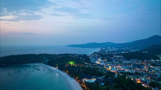 aerial hyperlapse view The lights twinkled along Kata beaches and Karon beach city at night..Kata beach and Karon beach..Bright colors along the beach city area at night..
